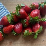 strawberries laying on a wooden cutting board
