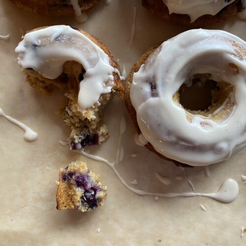two blueberry cake donuts with vanilla icing