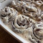 homemade from scratch chocolate sweet rolls in a dish with vanilla icing