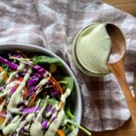 chick fil a avocado lime ranch dressing drizzled on a salad and in a glass mason jar