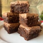 frosted sourdough brownies stacked on top of each other