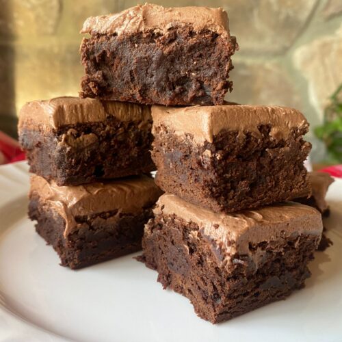 frosted sourdough brownies stacked on top of each other
