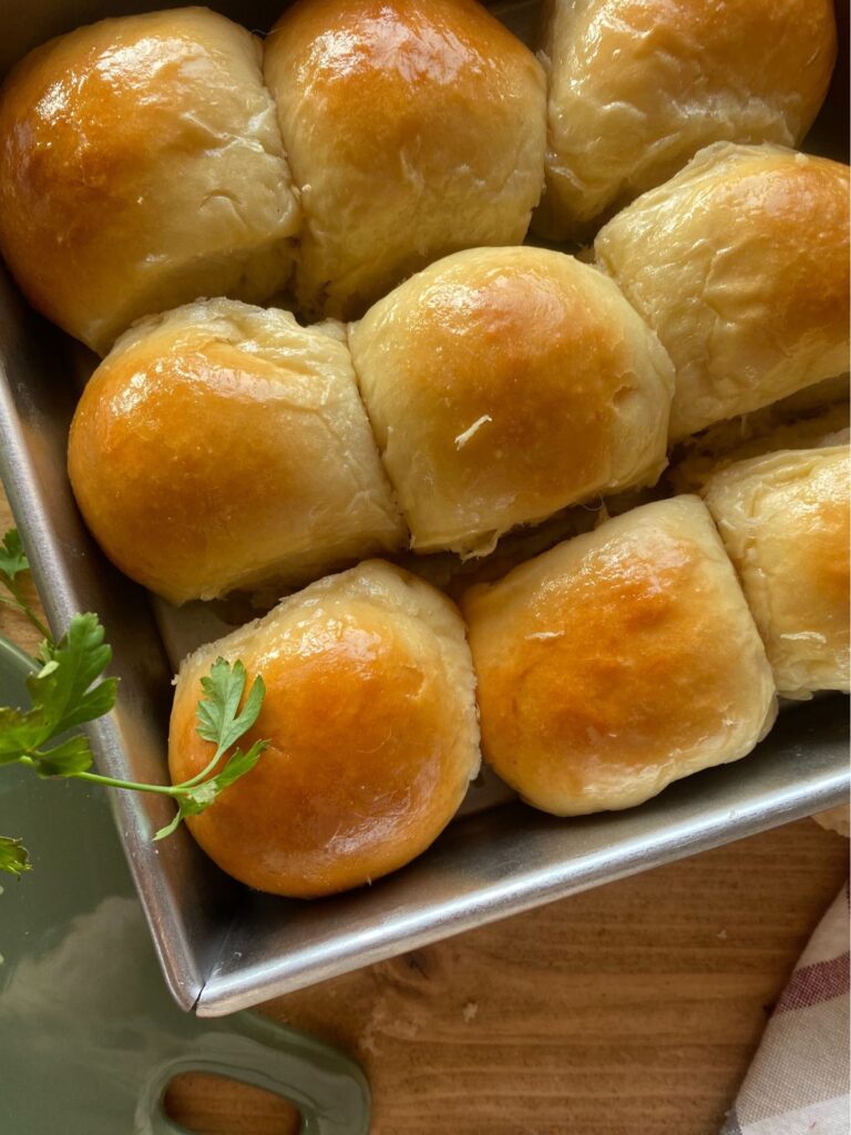 baked homemade Hawaiian rolls nestled together in a square pan