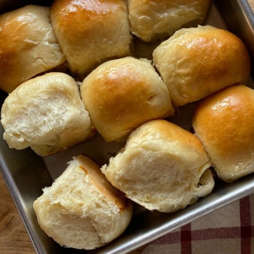 baked homemade Hawaiian rolls nestled together in a square pan
