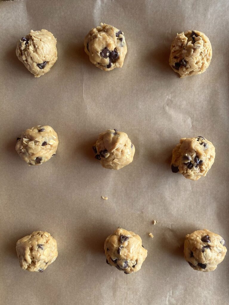 balls of peanut butter oatmeal sourdough cookies on a baking sheet