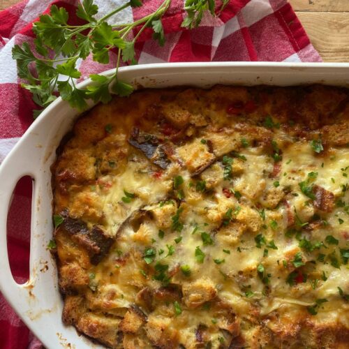 bacon and cheddar sourdough breakfast casserole baked in a white casserole dish