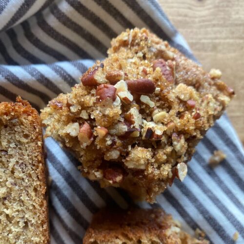 slices of sourdough discard banana bread sit on a striped towel