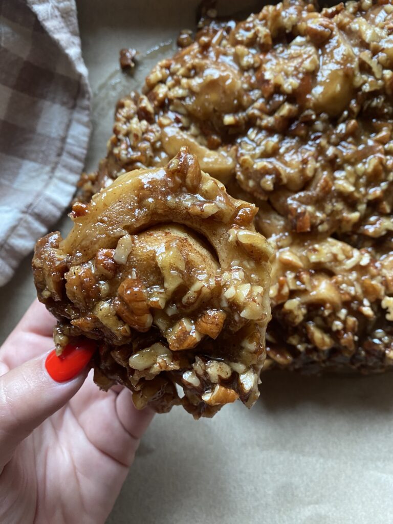 a close up view of a sourdough sticky bun with a brown sugar pecan topping