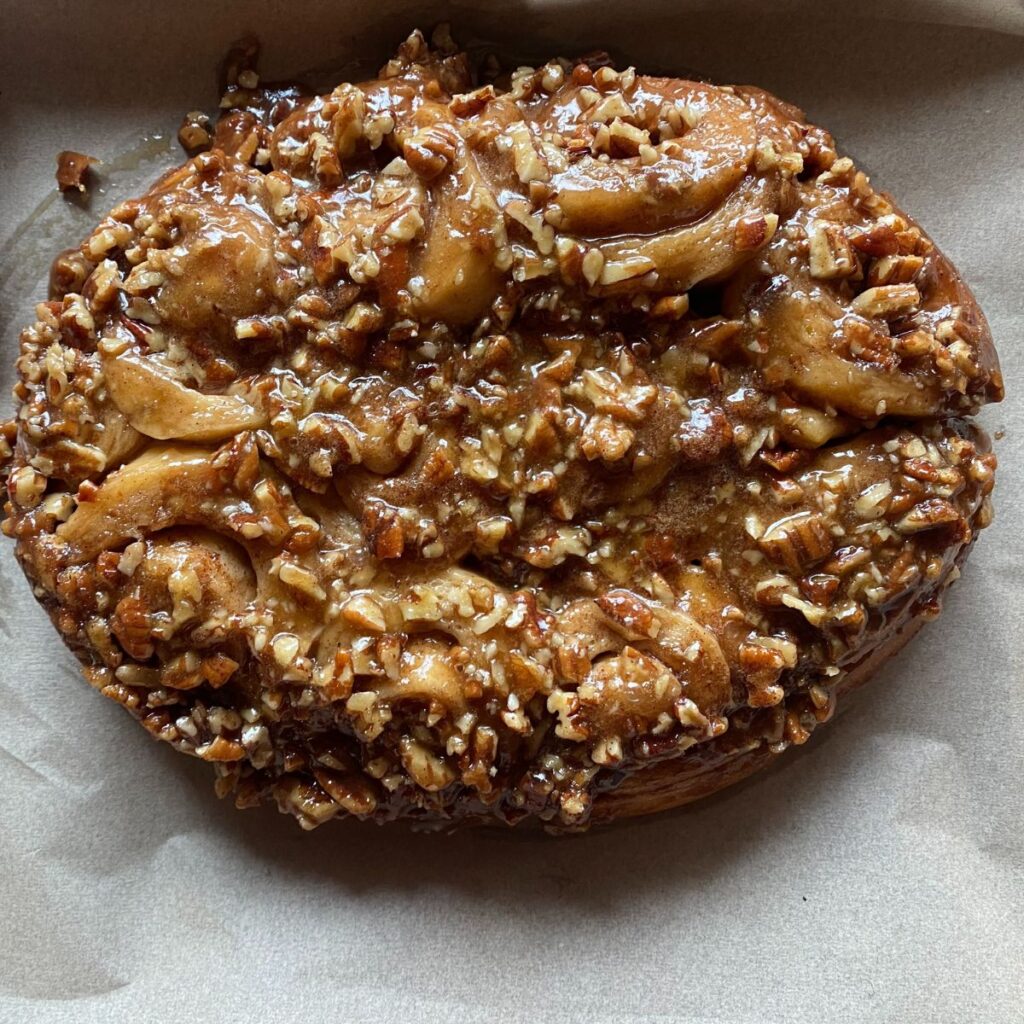 a close up view of sourdough sticky buns with a brown sugar pecan topping