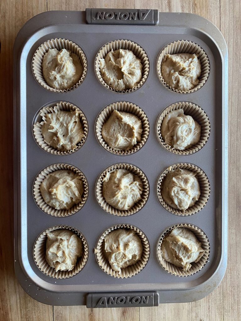 a 12 count muffin tin filled with coffee cake muffin batter