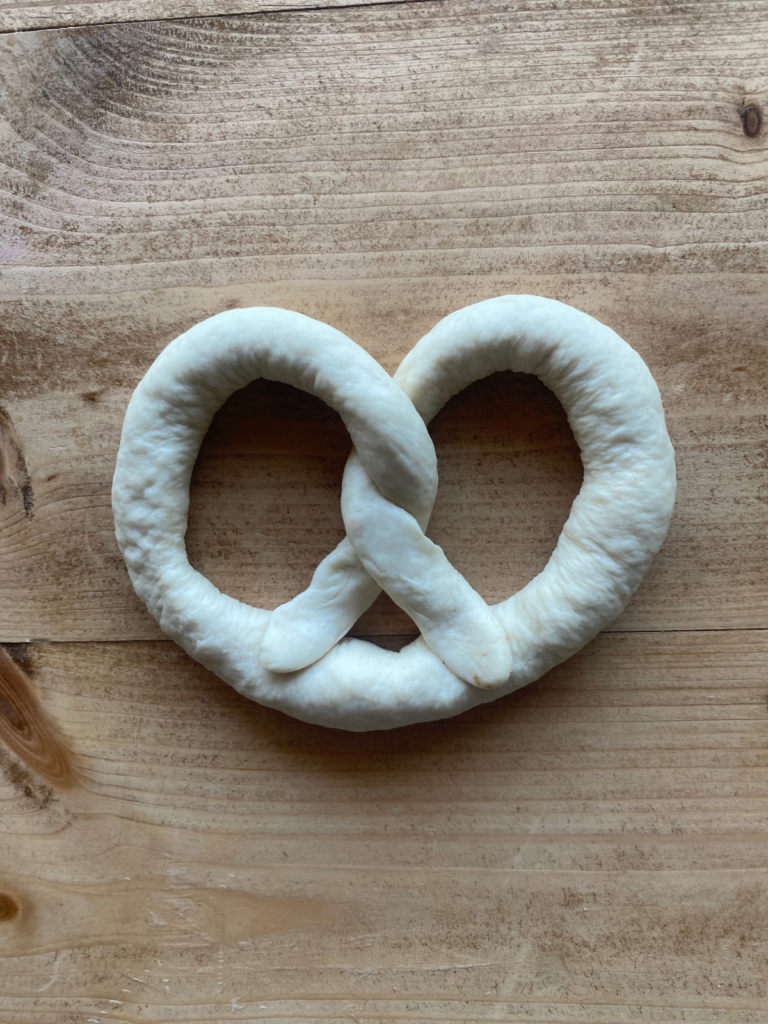 a completed sourdough soft pretzel on a wooden countertop