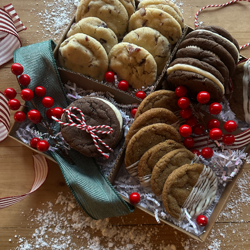 A festive Christmas cookie box filled with a variety of Christmas cookies, along with red berries and red and white striped ribbon