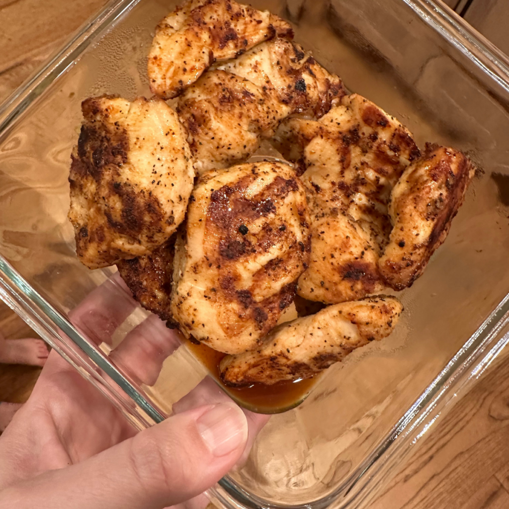 cooked pieces of air fryer chicken breast in a glass container