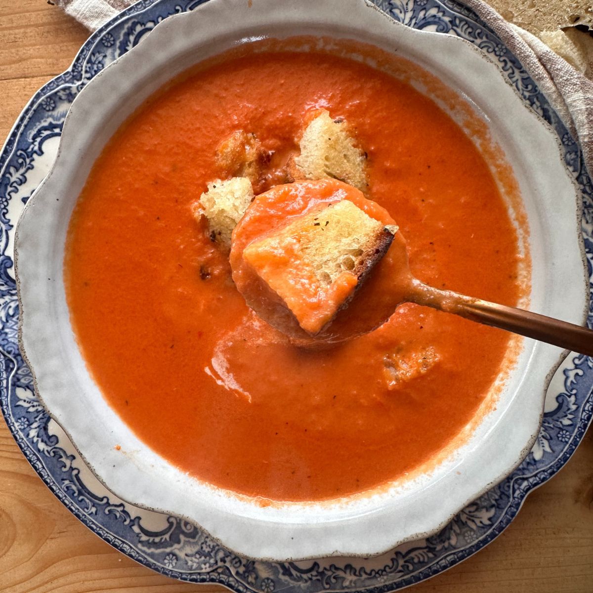 a bowl of creamy tomato soup, topped with toasted sourdough breadcrumbs