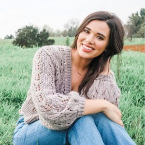 a girl sitting in a field of green grass