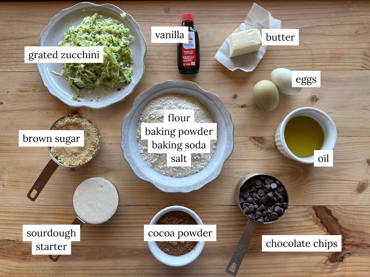 a labeled ingredient photo of ingredients needed to make sourdough chocolate zucchini muffins
