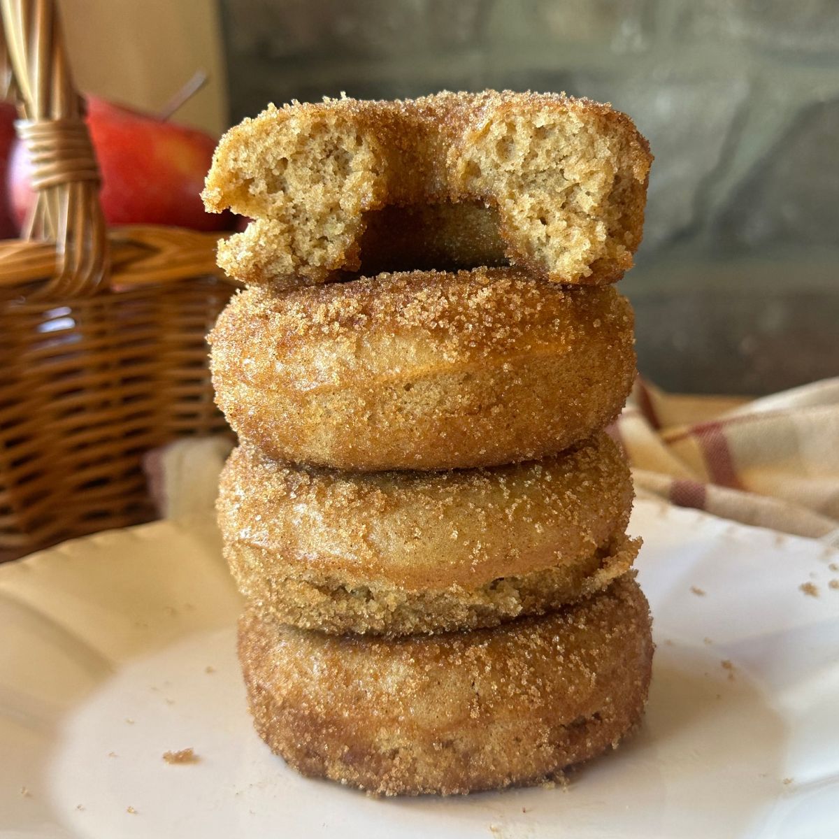 a stack of baked apple cider donuts on a white plate